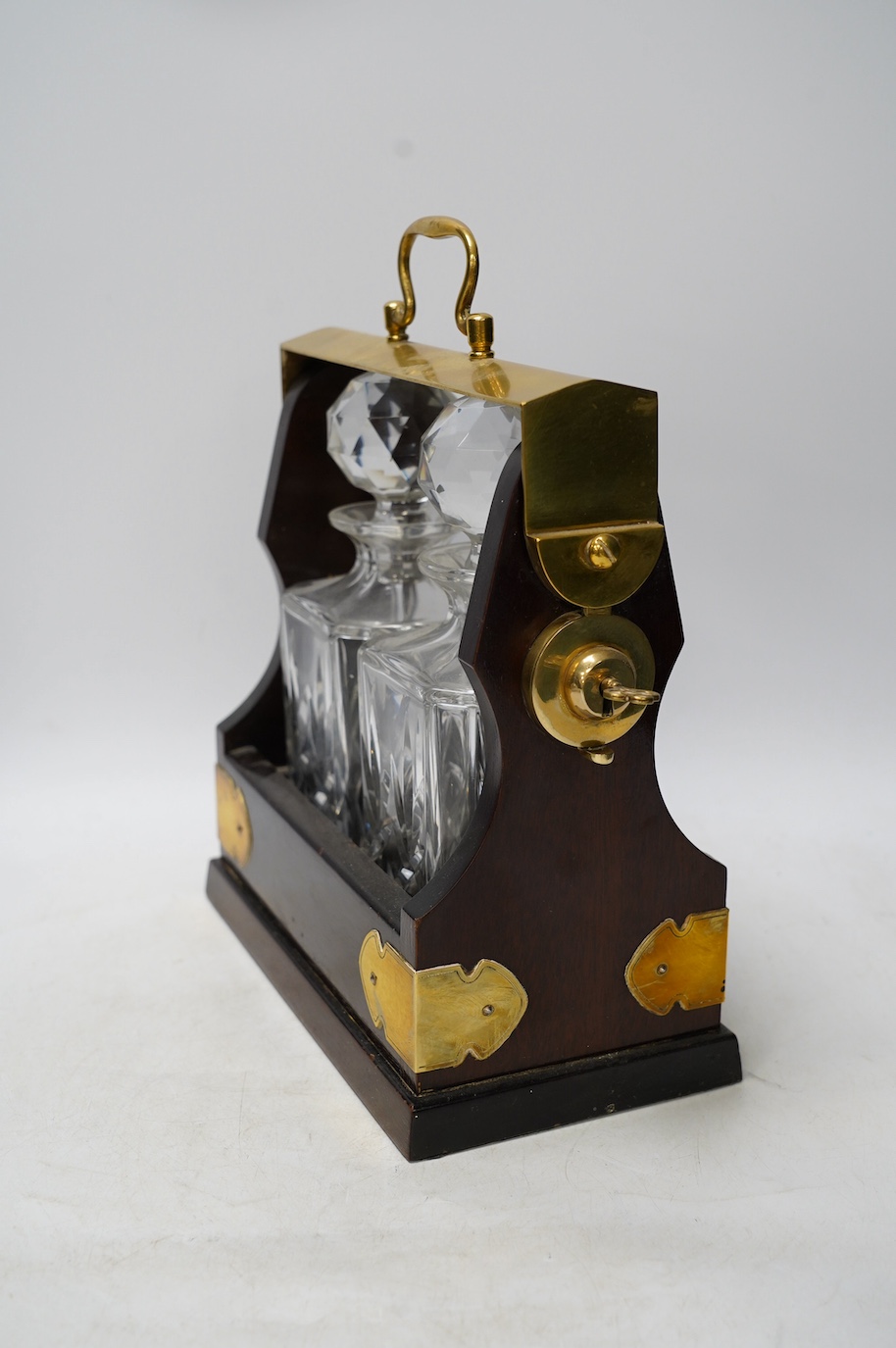 A brass mounted two bottle tantalus and three glass decanters / jugs, largest 32cm high. Condition - fair